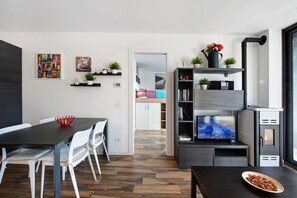 Un espace de vie moderne comprenant un coin repas, une cuisine et un téléviseur.
