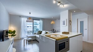 A compact living space with a kitchenette, a dining area, and a seating area with a view.