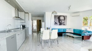 Ett modernt kök med en matplats, en soffa och ett stort fönster.