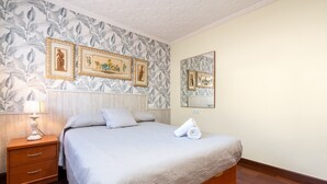 A hotel room with a bed, a nightstand, a lamp, and framed pictures on the wall. - Chalet 'Casa Thaiker' with Mountain Views, Garden, BBQ & A/C (Miami playa.  Tarragona)