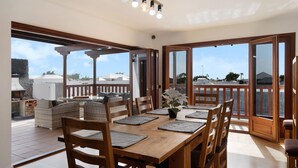 An open-plan dining area with a wooden table, chairs, and a view of the outdoors. - Villa Peaky with Sea & Mountain View, Pool & Sauna (Yazia)