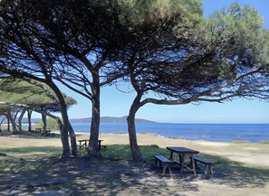 A beach with picnic tables and trees. - Holiday Apartment "Prenda Home Holiday " with Balcony, Wi-Fi and Sea View (Posada)