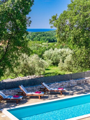 A poolside area with lounge chairs and a view of a natural landscape. - Pure relaxation - villa with pool for 6 persons (Bale)