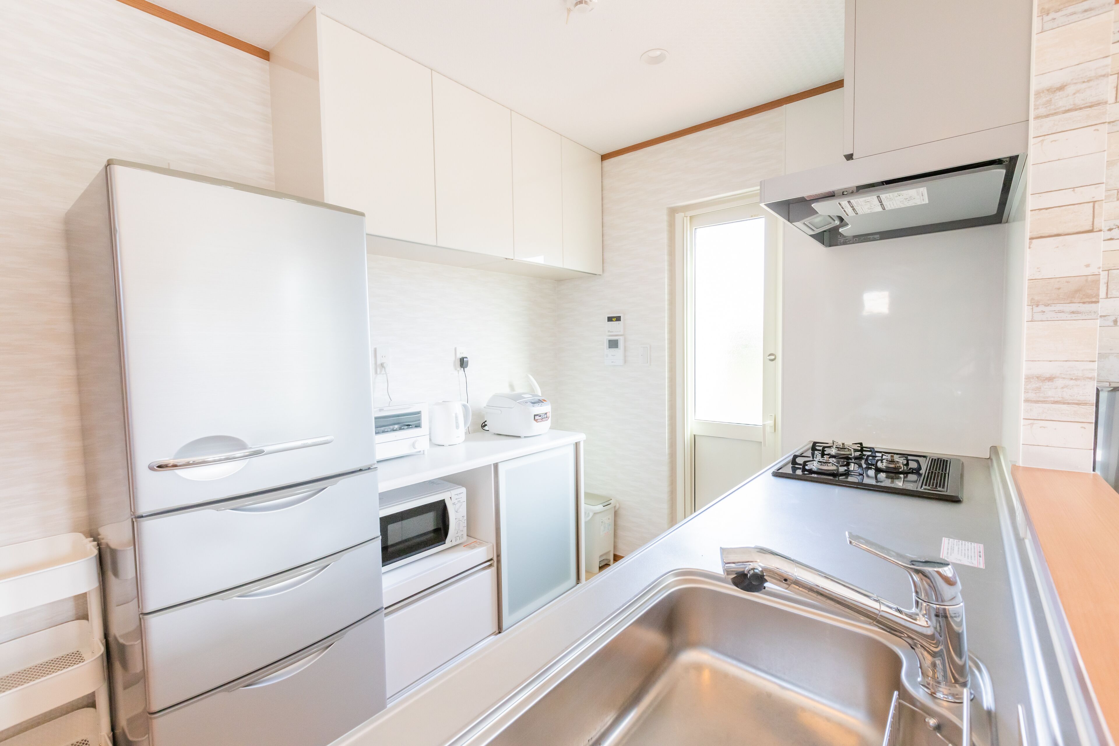 Una cocina moderna con electrodomésticos de acero inoxidable, horno empotrado y cocina a gas.