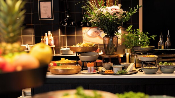 Una mesa de buffet con diversos platos y un centro de mesa floral.