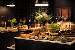 A buffet setup with various dishes and a centerpiece of flowers. - Home Hotel 1624 (Kongsberg)