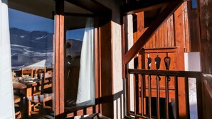 A wooden staircase leading to a dining area with a mountain view.