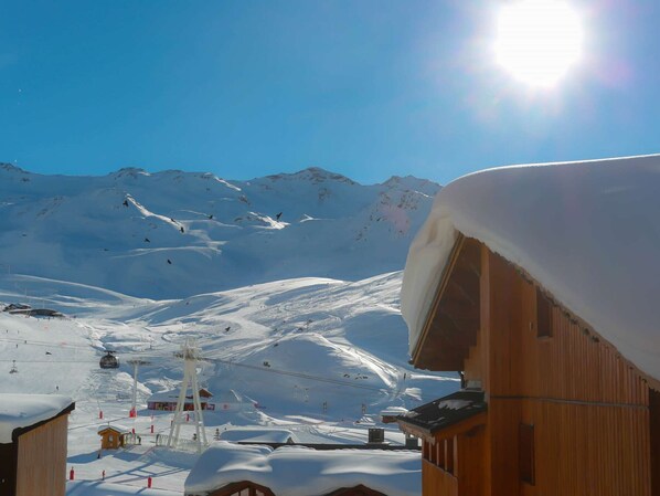 A snow-covered mountain with a ski lift and buildings in the foreground. - Charming Triplex Chalet in Val Thorens - 6 Guests, 2 Balconies, Fireplace, Ski-In/Ski-Out (Val Thorens)