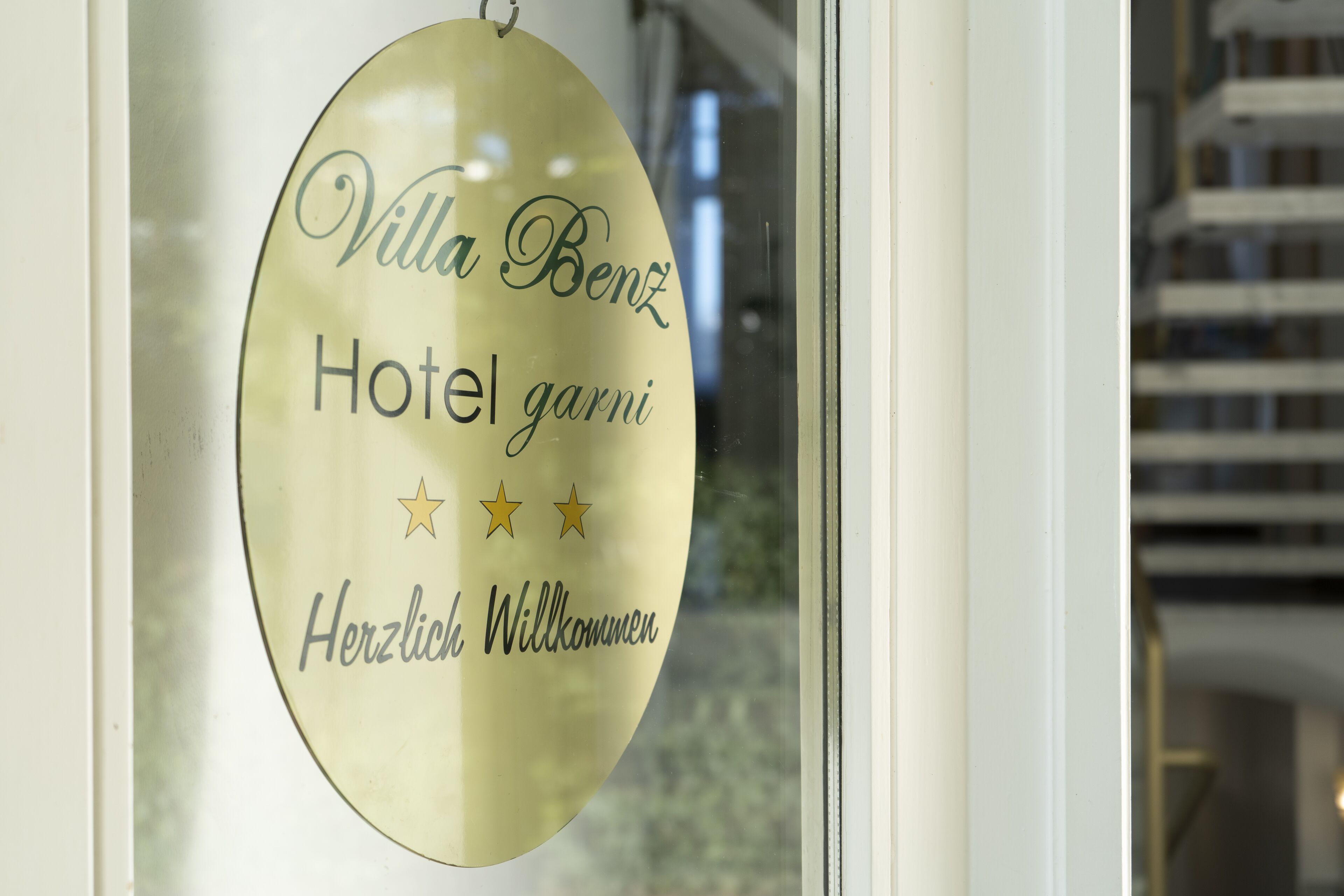 A sign with the text "Villa Benz Hotel garni Herzliche Willkommen" and three stars.