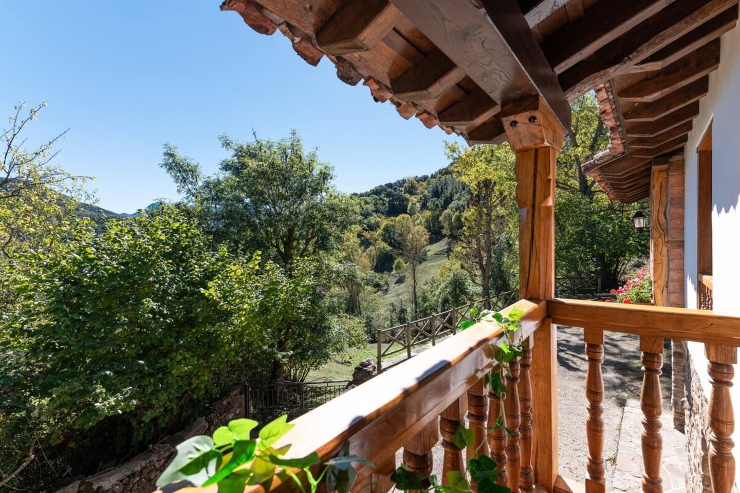 Ein hölzerner Balkon mit Blick auf eine üppige grüne Landschaft und Hügel.