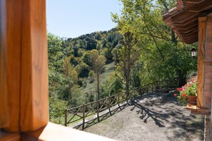 Ein hölzerner Balkon mit Blick auf eine hügelige Landschaft.