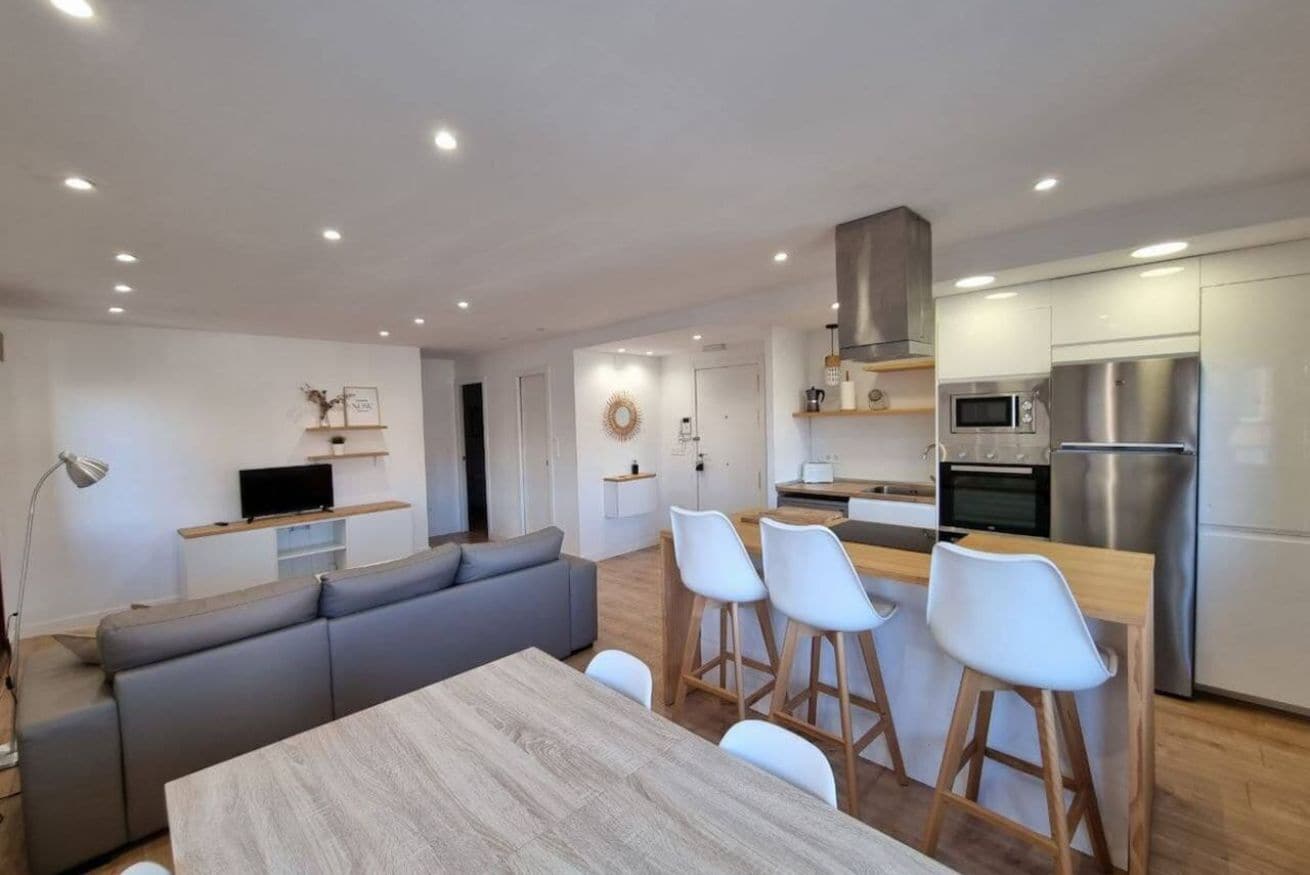 Una cucina moderna con zona pranzo, divano e televisione.