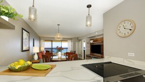 A modern kitchen with a built-in stove, dining area with a view, and a large clock on the wall. - Amazing OCEAN VIEWS, Full Kitchen, Washer/Dryer, Pool, Newly Renovated 2018 (Honolulu)