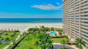 Ein Hotel mit Pool, Blick auf den Strand und üppiger Vegetation.