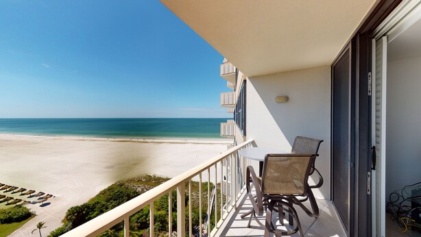 Ein Balkon mit Blick auf Strand und Meer.