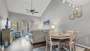 Un vaste espace de vie comprenant une table à manger, des chaises et un ventilateur de plafond.