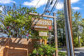 A wooden sign for 'Lokelani Condominiums' with a house number '3833'.