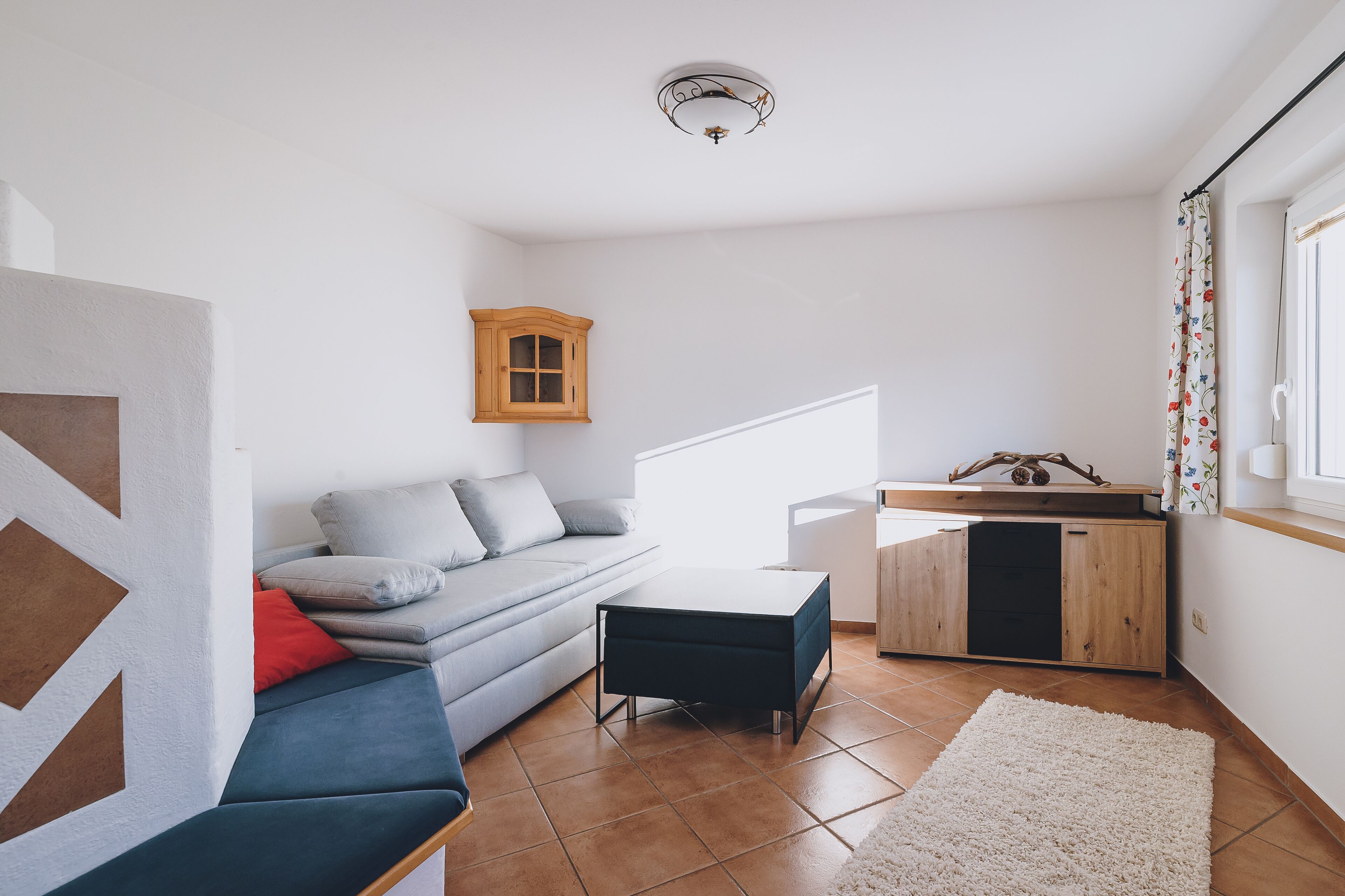 Una sala moderna con un sofá, una mesa de centro y un mueble pequeño.