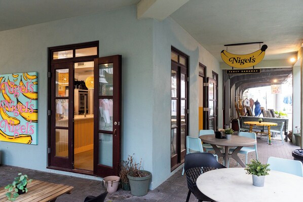 A café with outdoor seating, a colorful mural, and a sign for 'Nigel's Fancy Bananas'. - Two Bedroom Guest Home in Seaside, Fl. Open-Air Deck, + 2 Adult Bikes! (Santa Rosa Beach)