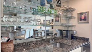 A kitchen with a granite countertop, a sink, and a glass display case with various glassware. - 7th Floor!!  Recently Redecorated, Lazy River and Slide!! (Orange Beach)