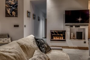 Un salon moderne avec une cheminée, un téléviseur à écran plat et un canapé confortable.