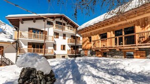 A two-story wooden chalet with balconies, surrounded by snow. - Chalet, 50m from ski slopes, view mountain, terrace, fireplace or stove, tv, ski locker, 130m² (Tignes)