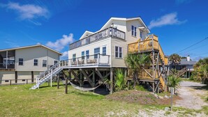 A two-story house with a balcony and a wooden deck.