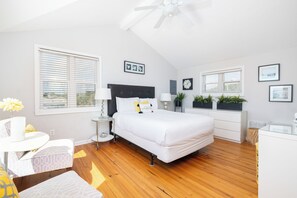 A modern bedroom with a bed, bedside tables, a desk, and a chair. - "The Retreat" at Dolphin's Watch - Up (Folly Beach)