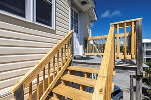 A residential building with a wooden staircase leading to a porch.