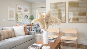 Ein Wohnzimmer mit einer Couch, Sesseln, einem Couchtisch und Kunstwerken an den Wänden.