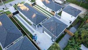 Vista aérea de una zona residencial con varias casas, cada una con techo inclinado y jardín delantero.