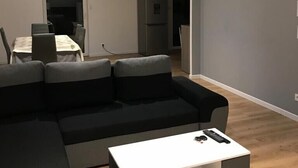 A modern living room with a sectional sofa, a white coffee table, and a dining area in the background. - Maison duplex 90 m2 6 km from Bordeaux center (Floirac)