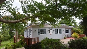 Villa Bonita met een witte gevel, een pannendak en een muurschildering van een vrouwenportret.