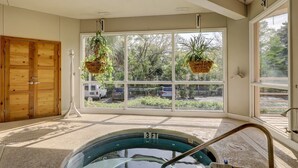 Une pièce dotée d’une grande fenêtre, d’une porte en bois et d’un jacuzzi.