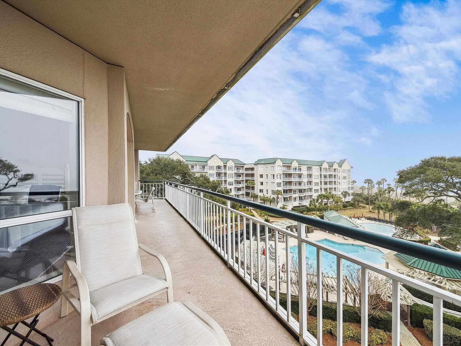 Un balcone con vista su una piscina e un complesso di edifici.