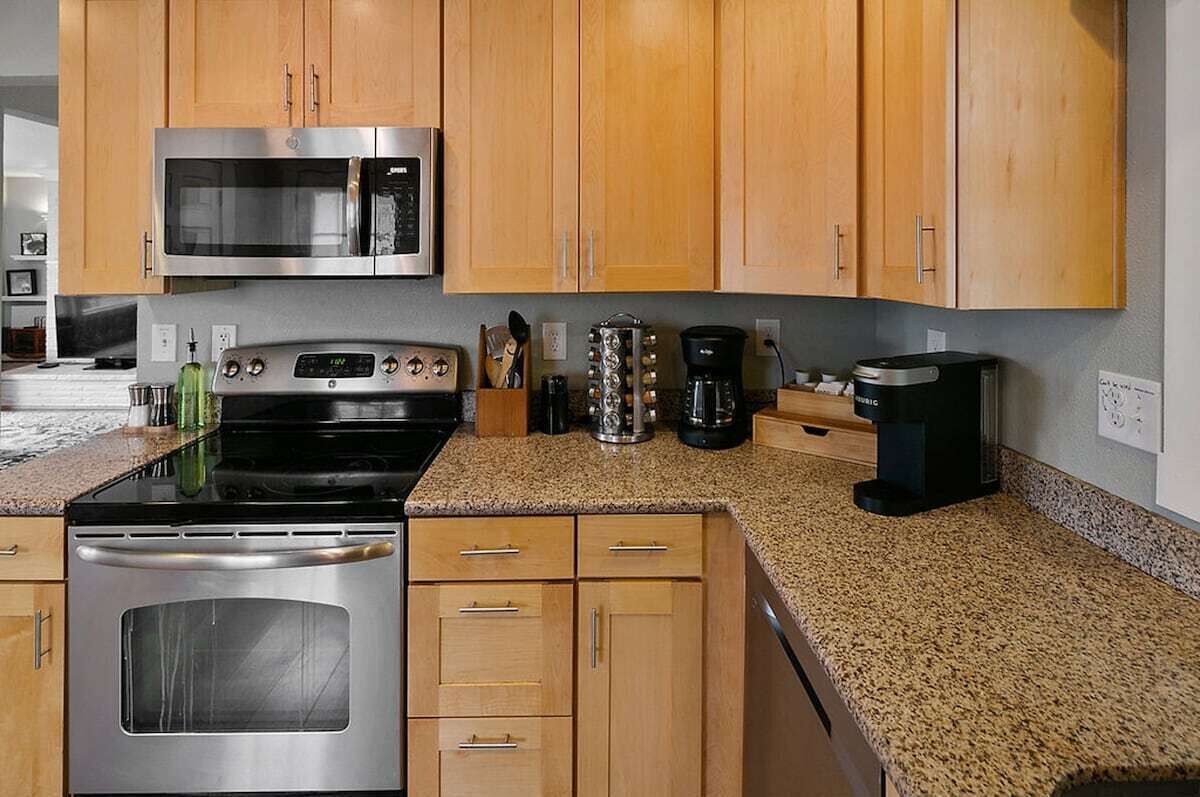 Kitchen is stocked with spice rack, Keurig coffee machine with K-cups, creamer, sugar, tea, pots and pans, dinnerware, silverware, and lots more