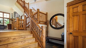 Eine Holztreppe mit einer Holztür und einem runden Spiegel an der Wand.