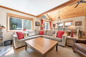 A cozy living room with a sectional sofa, a wooden coffee table, and a fireplace.