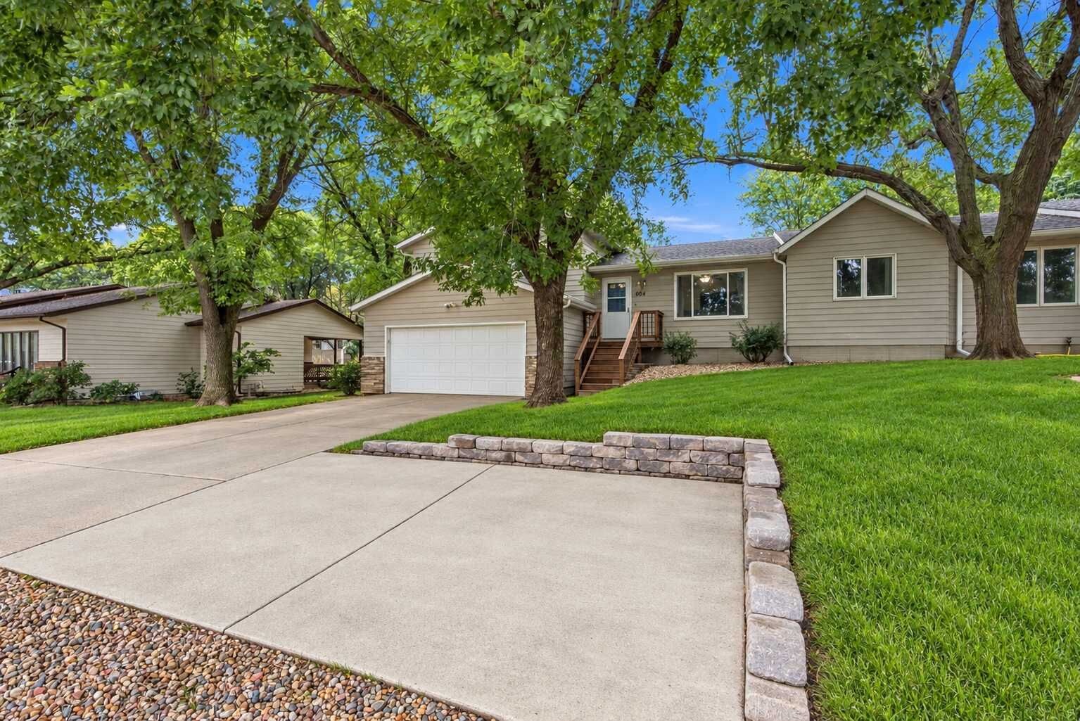 A residential property with a driveway, a garage, and a well-maintained lawn.