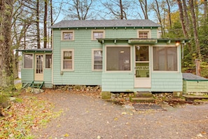 A small, single-story building with a green exterior and a porch.