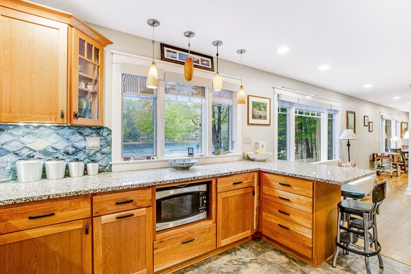 A spacious kitchen with wooden cabinets, a granite countertop, and a large island.