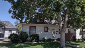 A single-story house with a front yard, a driveway, and a tree. - Rancher's Capitol Lodge (Historic) - Steps away from the Capitol and Downtown (Cheyenne)