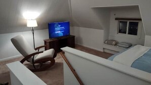 A bedroom with a bed, a chair, a TV, and a small window. - Rancher's Capitol Lodge (Historic) - Steps away from the Capitol and Downtown (Cheyenne)