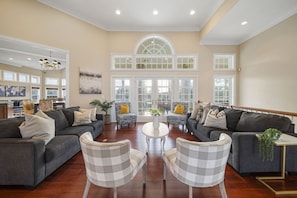 A spacious living room with two sofas, a coffee table, and patterned chairs.