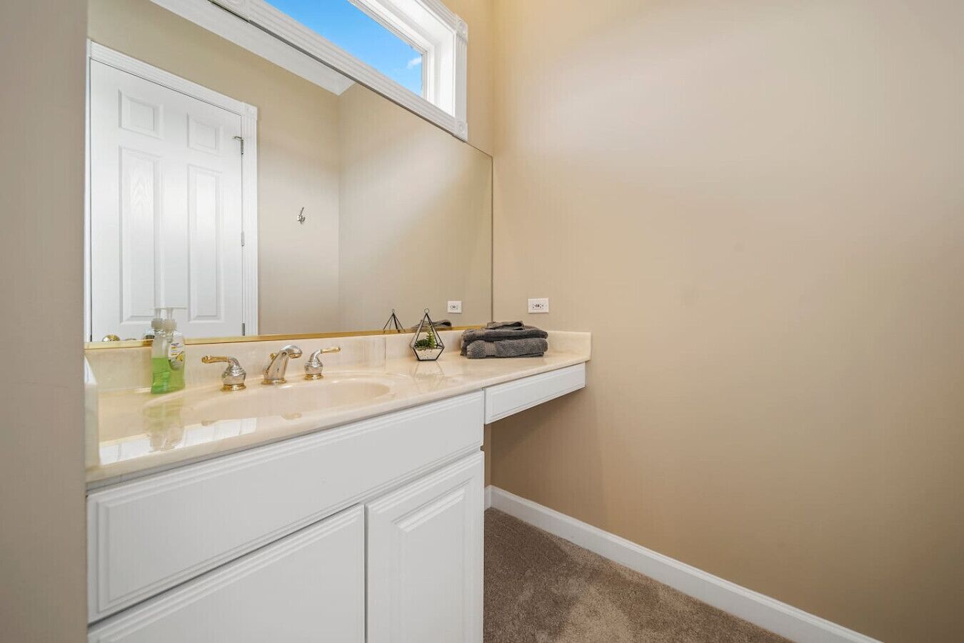 Une salle de bain avec un meuble-lavabo blanc, deux vasques, un miroir et un porte-serviettes.