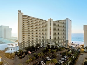 A high-rise hotel with a central atrium, multiple floors, and a view of the ocean. - Sugar-White Beachfront Living  - Incredible Views - Unit #1112 (Destin)