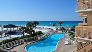 A pool area with a view of the beach and ocean.