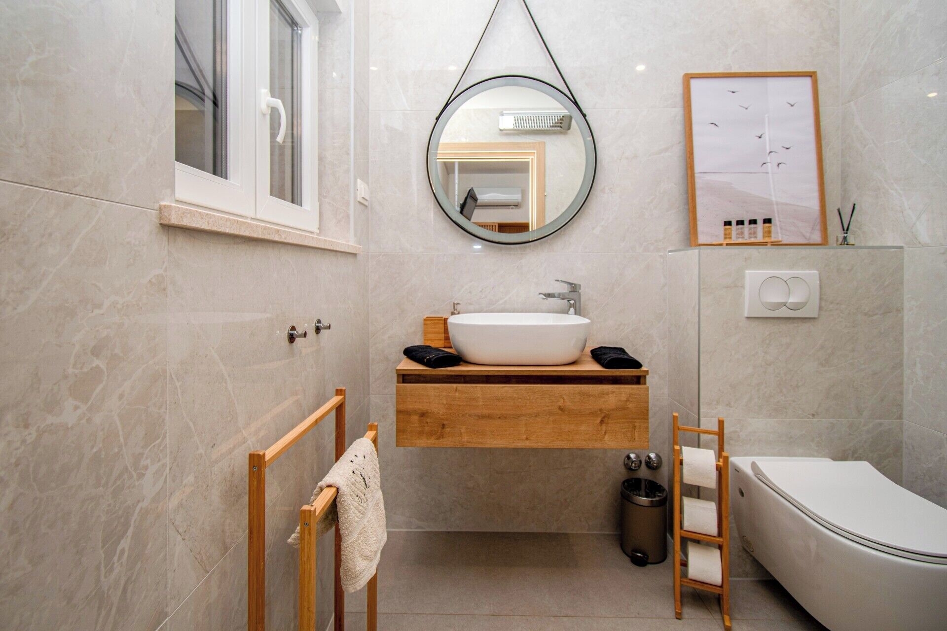 A modern bathroom with a freestanding sink, a toilet, and a shower area.