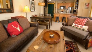 Un salon comprenant deux canapés, une table basse et un coin repas avec une table et des chaises.