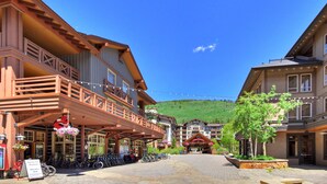 Un bâtiment avec une façade en bois, un balcon et une enseigne indiquant un service de location de vélos.